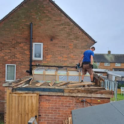 Worker stripping old roof felt