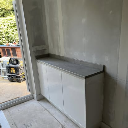 White kitchen utility room with stone worktop and window