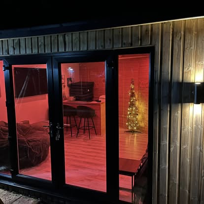 Garden room at night with black bifold doors
