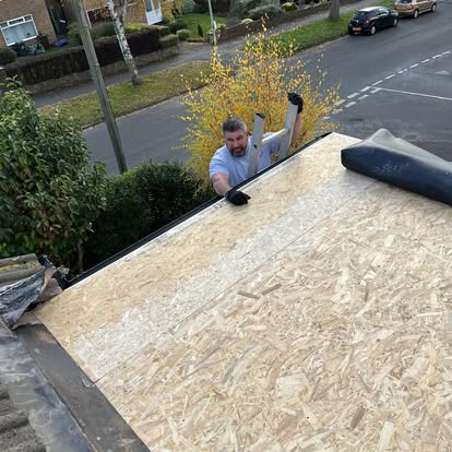 Roofer working on OSB flat roof residential