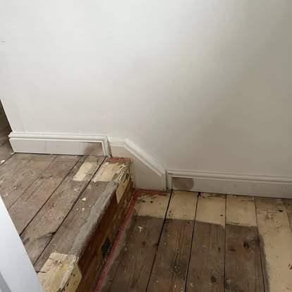 Old floorboards and new skirting board installation