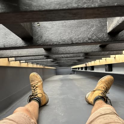 Worker under composite balcony decking frame