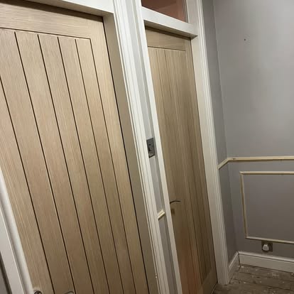 Two oak doors in hallway with panelling