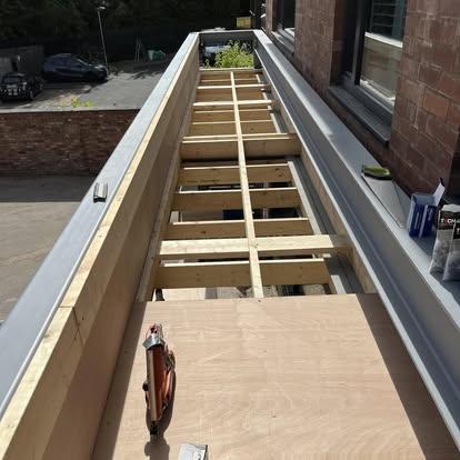Timber decking sub-frame against brick building