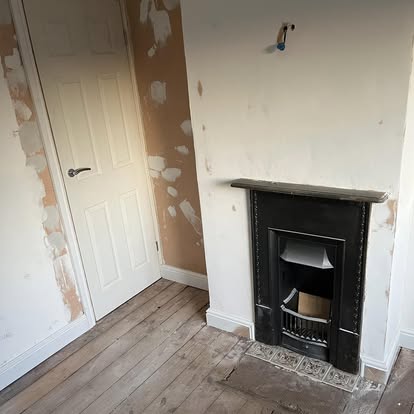 Room being refurbished with fireplace stripped walls