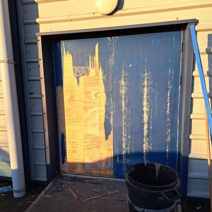 Door being fitted to horizontal-clad commercial building