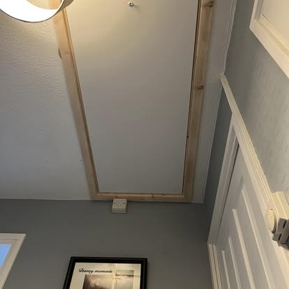 New loft hatch frame being fitted in hallway ceiling