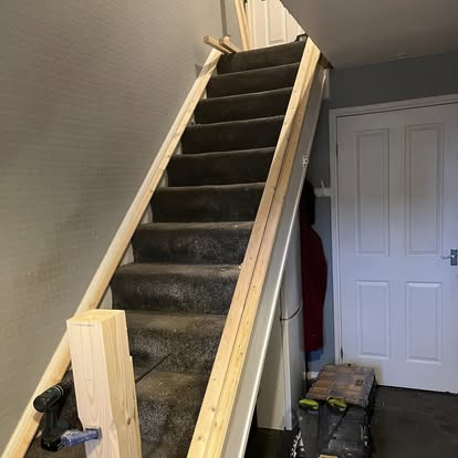 New pine stair balustrade being fitted from below