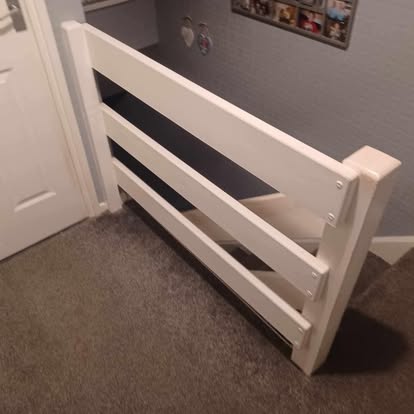 White painted stair gate at top of stairs