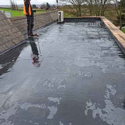 Worker applying EPDM on farm building roof