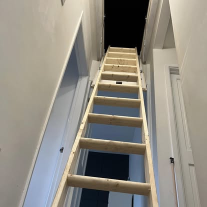 Loft ladder fully extended into loft opening