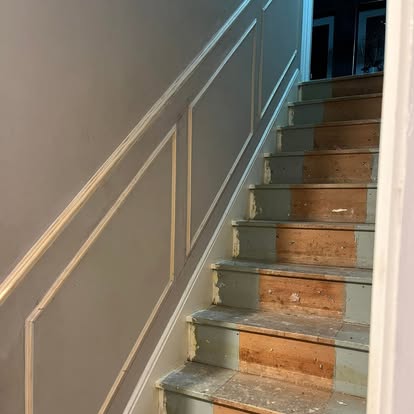 Staircase wall panelling being fitted in hallway