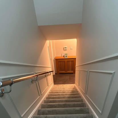 Staircase with chrome handrail and warm lighting