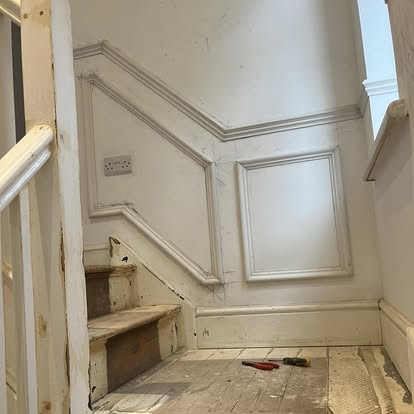 Staircase with wall panelling and tools during work