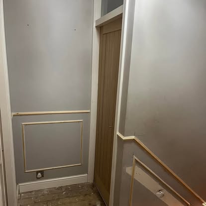 Staircase area with panelling and oak door being fitted