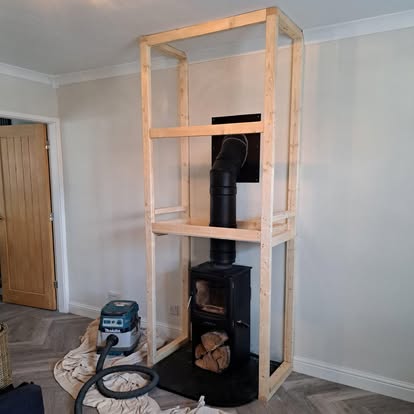 Timber stud frame being built around wood burner stove