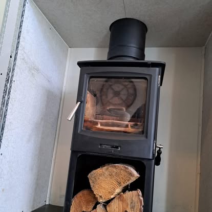 Wood burner door close-up with log store below