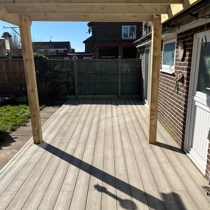 Composite decking boards being laid with timber pergola