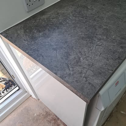 Dark stone worktop close-up on white utility cabinet