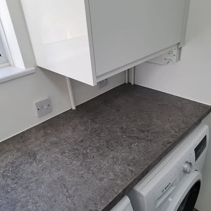 White gloss wall cabinet fitted above dark worktop