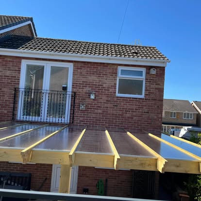 Polycarbonate roof panels being fitted on timber pergola