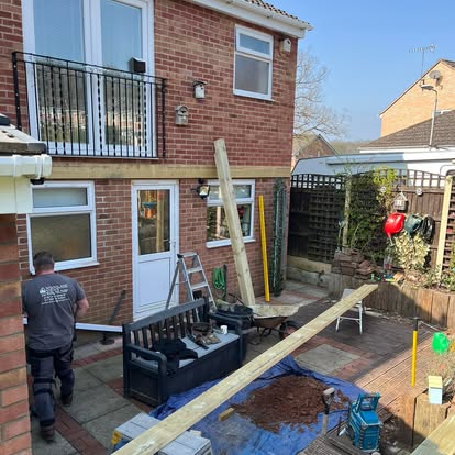 Worker laying decking subframe in back garden