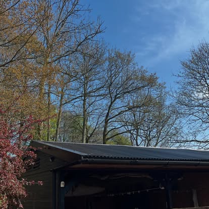 Black corrugated roof on dark timber building rural setting
