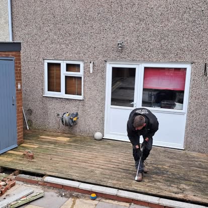 Worker laying dark composite decking boards on terrace