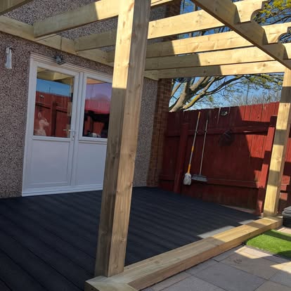 Dark composite decking with timber pergola completed
