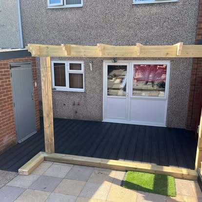 Completed dark composite decking with timber pergola