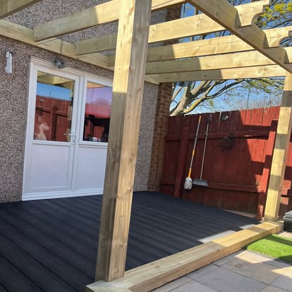 Completed dark composite decking and timber pergola side view