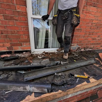 Worker removing old roofing material at Victorian terrace bay
