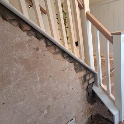 Victorian staircase renovation with brick wall and stained glass