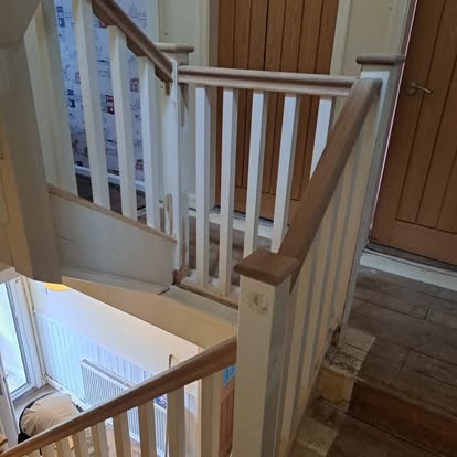 White staircase with ball newels and stained glass