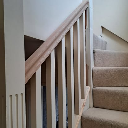 Square spindle staircase with oak rail and carpet