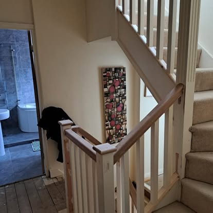 Square spindle staircase with oak rail and artwork