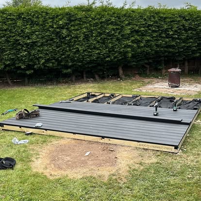 Grey composite deck laid with pergola frame starting