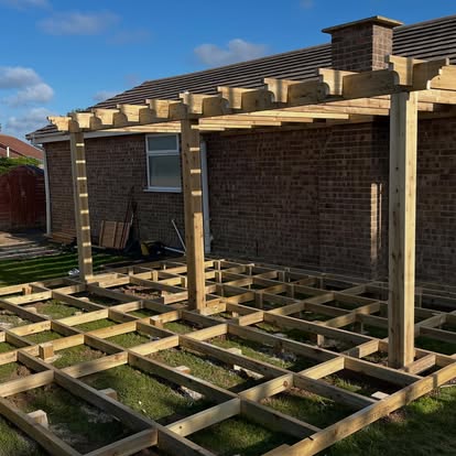 Timber pergola frame with scalloped brackets at bungalow