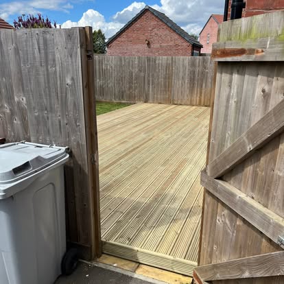 New timber decking viewed through gate at new build