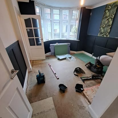 Bay window room with floor being stripped for renovation