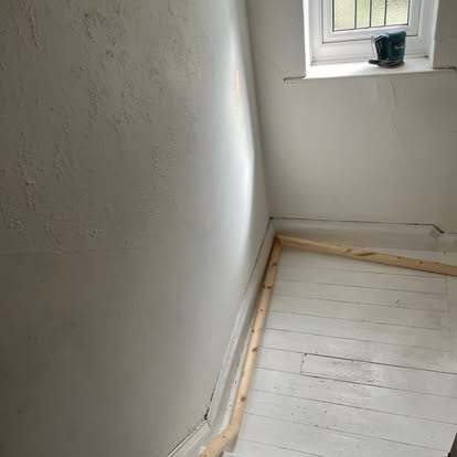 White painted staircase landing with leaded window