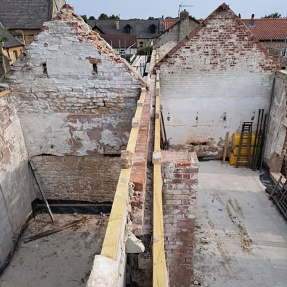 Old brick building with new timber wall plates on top
