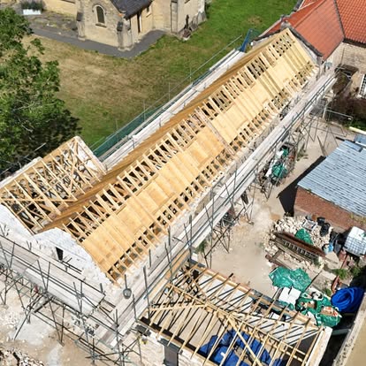 Aerial view of stone barn with new long roof structure