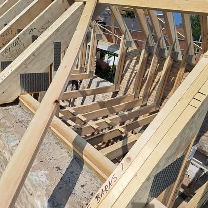 New timber roof trusses being erected on barn