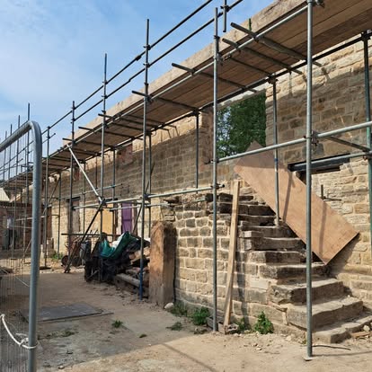 Historic stone building with scaffolding and stone steps