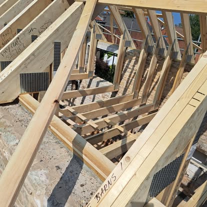 Timber barn roof trusses being installed