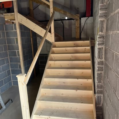 New pine staircase inside grey blockwork building