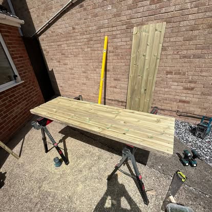Completed timber gate panel laid flat on sawhorses