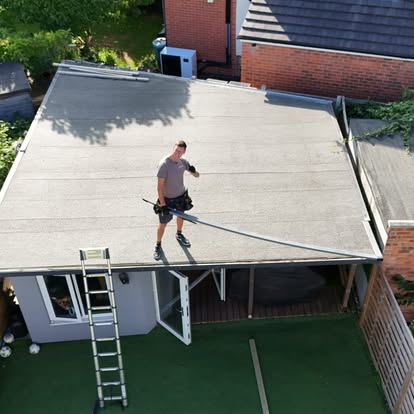 Worker on completed EPDM flat roof of garden room