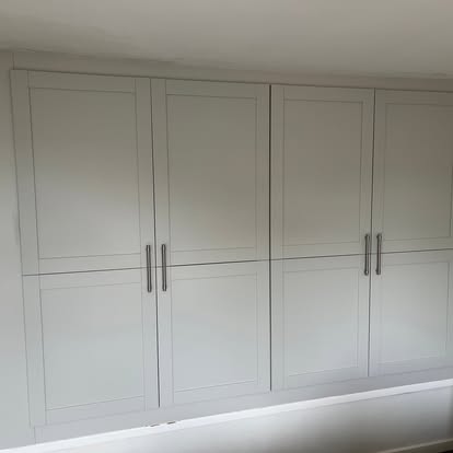 White fitted wardrobes with shaker doors and bar handles